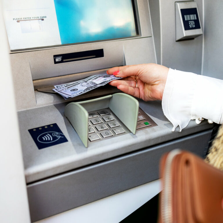 Middle age woman is withdrawing money from ATM machine