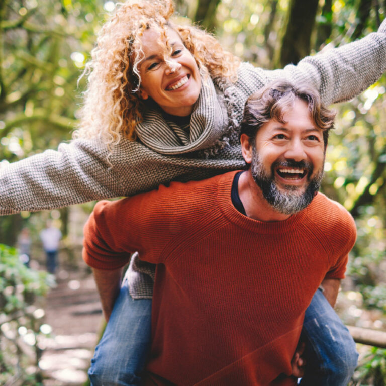 Overjoyed adult couple have fun together at outdoor park in leis