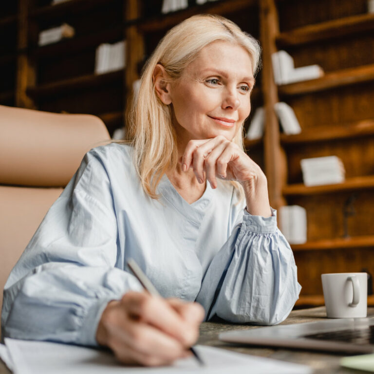 Smart caucasian mature middle-aged businesswoman CEO boss leader teacher writing, taking notes on laptop, e-learning , working remotely online in home office